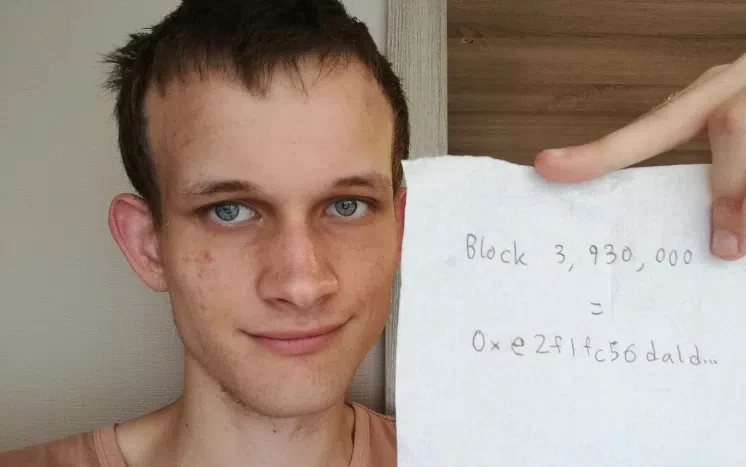 vitalik buterin tient un papier avec le block pos